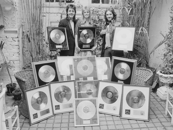 Paul McCartney, Linda McCartney and Denny Laine pose with the gold records awarded for their album 'Band On The Run', on May 2, 1974.