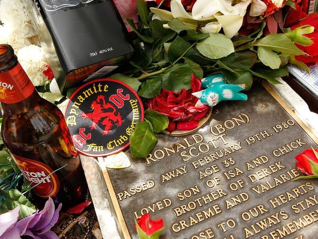 PERTH, AUSTRALIA - FEBRUARY 19: Tributes adorn the memorial of Bon Scott on the 30th anniversary of AC/DC's former frontman's death, at Fremantle cemetery on February 19, 2010 in Perth, Australia.  Scott died at the age of 33 in London from alcohol poisoning and was found in his car, where he initially fell asleep.  AC/DC are currently touring Australia with their "Black Ice"  tour, their first tour here since 2001. (Photo by Paul Kane/Getty Images)