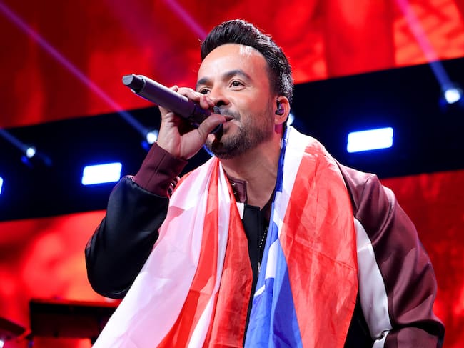 Luis Fonsi singing with the Puerto Rican flag around his neck